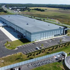Large modern warehouse building, numerous loading docks, vast parking lot, adjacent highway. | Down To Earth Landscaping | Jackson New Jersey, USA (732) 833-7702