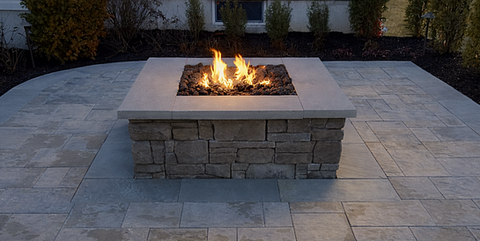 Square stone fire pit with burning flames on a paved patio. Residential landscaping near me| Down To Earth Landscaping | Jackson New Jersey, USA (732) 833-7702