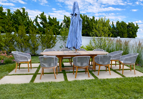 Outdoor dining set with wooden table and gray chairs on patio. Residential landscaping near me| Down To Earth Landscaping | Jackson New Jersey, USA (732) 833-7702