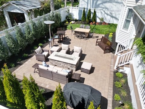 Landscaped backyard patio with fire pit, outdoor seating, and dining area. Residential landscaping near me| Down To Earth Landscaping | Jackson New Jersey, USA (732) 833-7702