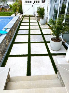 Modern patio with square pavers, grass strips, and covered pool. Residential landscaping near me| Down To Earth Landscaping | Jackson New Jersey, USA (732) 833-7702