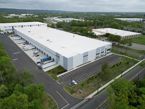 Large white industrial warehouse with loading docks and parked trucks. | Down To Earth Landscaping | Jackson New Jersey, USA (732) 833-7702