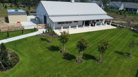 Modern barn-style building with white roof, long porch, and green lawn. | Down To Earth Landscaping | Jackson New Jersey, USA (732) 833-7702