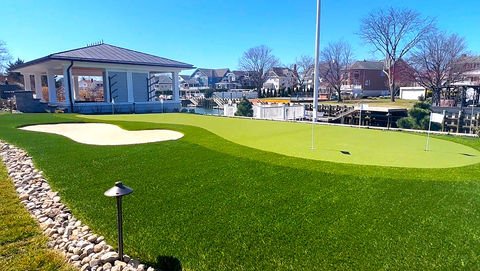 Backyard putting green with sand trap, gazebo, and waterfront homes. Residential landscaping near me| Down To Earth Landscaping | Jackson New Jersey, USA (732) 833-7702