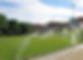 Sprinklers watering a large green lawn with buildings and trees in background. Commercial irrigation | Down To Earth Landscaping | Jackson New Jersey, USA (732) 833-7702