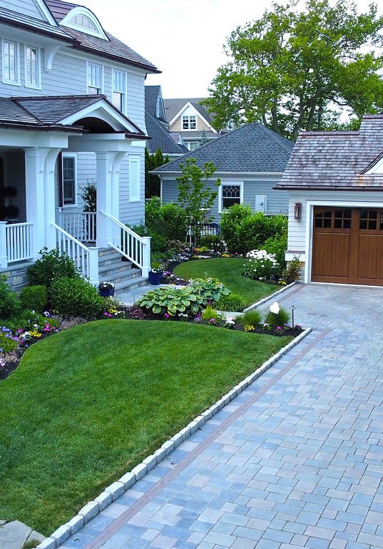 Large light gray house, manicured lawn services, paved driveway, and two-car garage. | Down To Earth Landscaping | Jackson New Jersey, USA (732) 833-7702